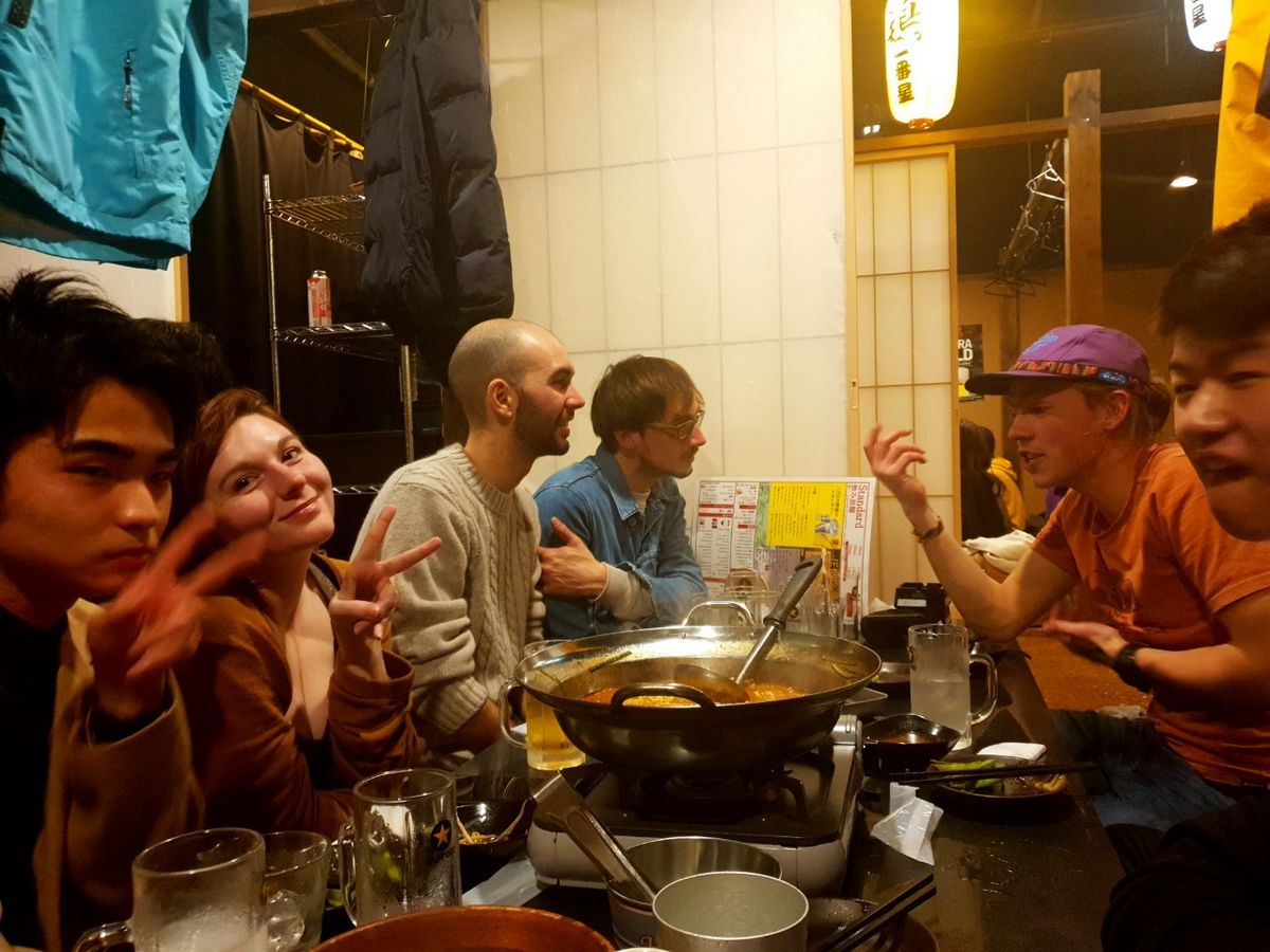 Bild Tohoku Studierende die Spaß haben und sich lachend unterhalten, abends in einem Restaurant in Sendai.