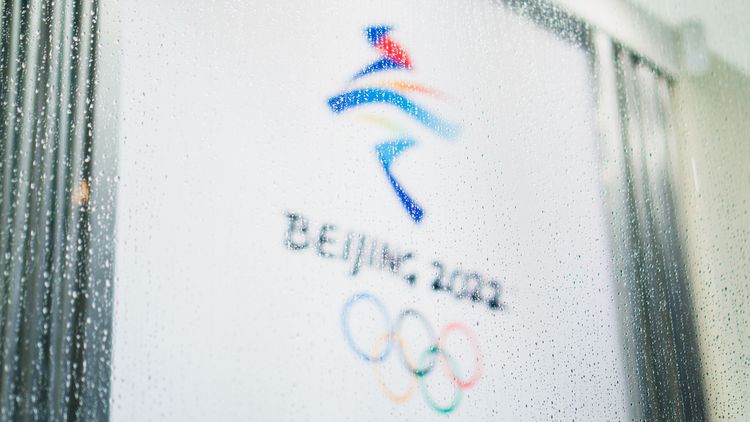 Olympia-Logo hOlympic logo behind a pane wetted with raindrops.