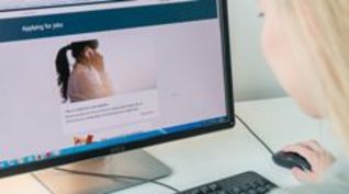 Eine Person vor einem Computer.