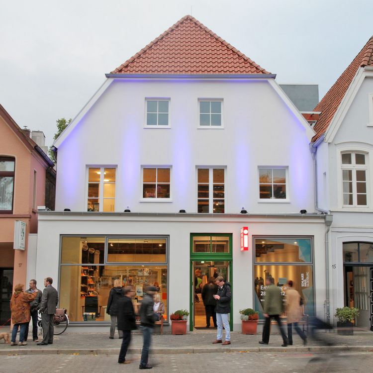 Das Bild zeigt das zweistöckige Schlaue Haus von der Rückseite. Es befindet sich in der Nähe des Schlosses Oldenburg. Die Rückseite ist weiß gestrichen.