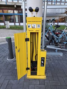 Ein Foto der gelben Fahrradservicestation vor dem A1 Gebäude.