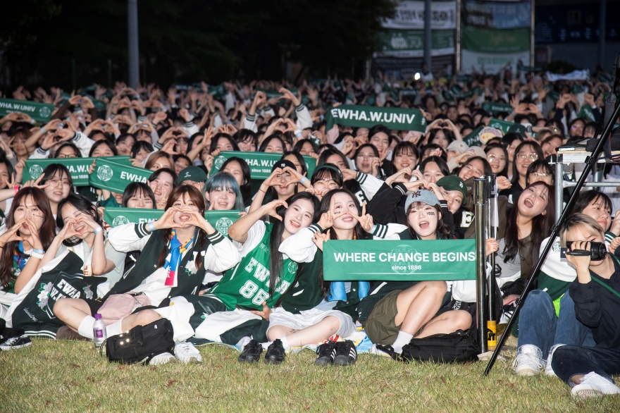 Ewha Womans University festival Studentinnen der Ewha Womans University in grüner Kleidung jubeln und werfen ihre Hände in die Luft.