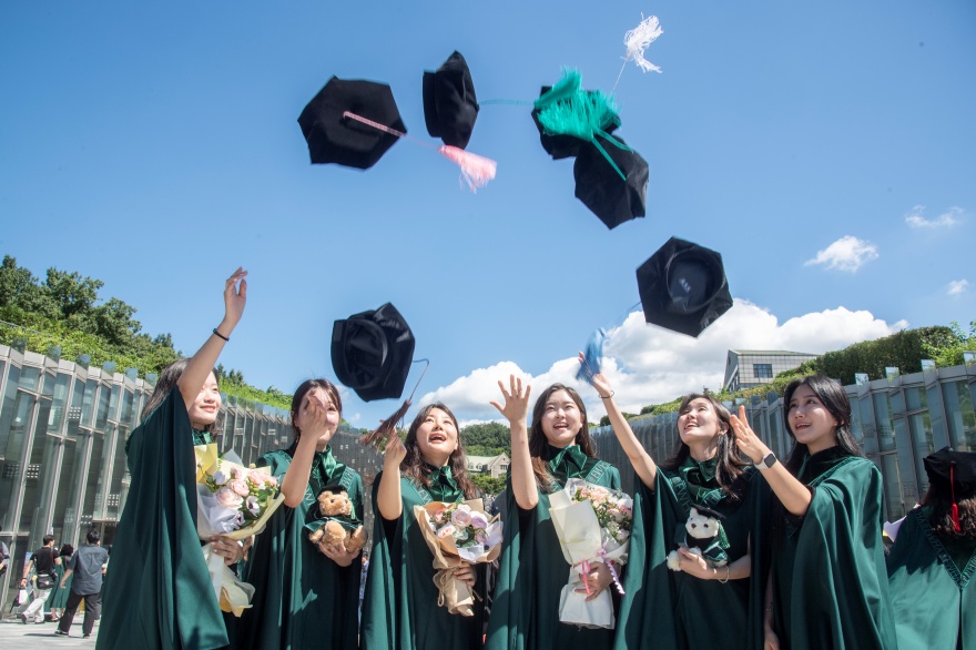Ewha Womans University Graduation Studentinnen der Ewha Womans University werfen ihre Abschlussmützen in die Luft.