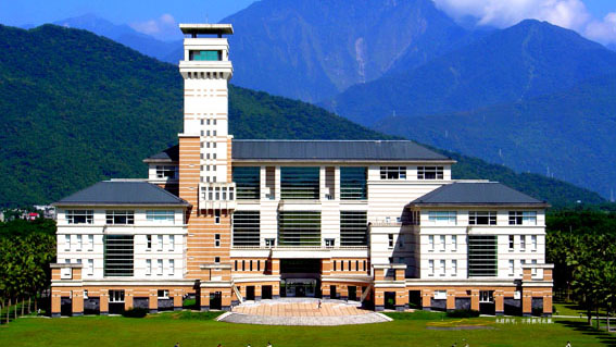 NDHU Universitätsgebäude Ein modernes Gebäude der National Dong Hwa University vor einer Berglandschaft.