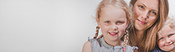 Anna und zwei Kinder, lächelnd, vor weißem Hintergrund